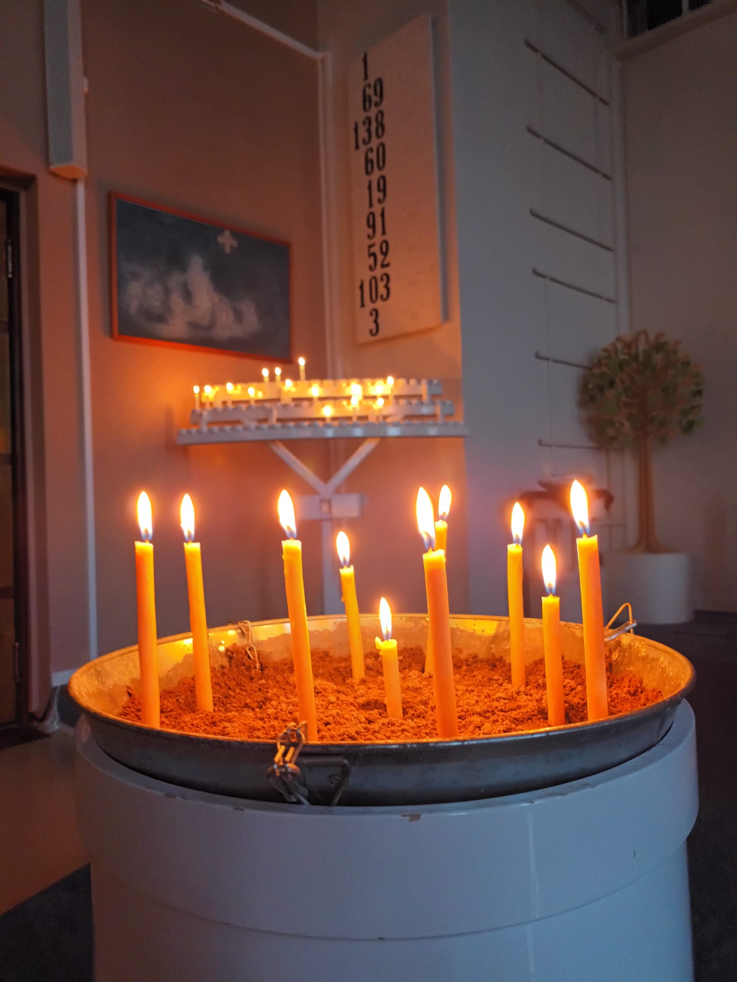 Tuohuskynttilät palava hiekka-astiassa Tainionkosken kirkossa