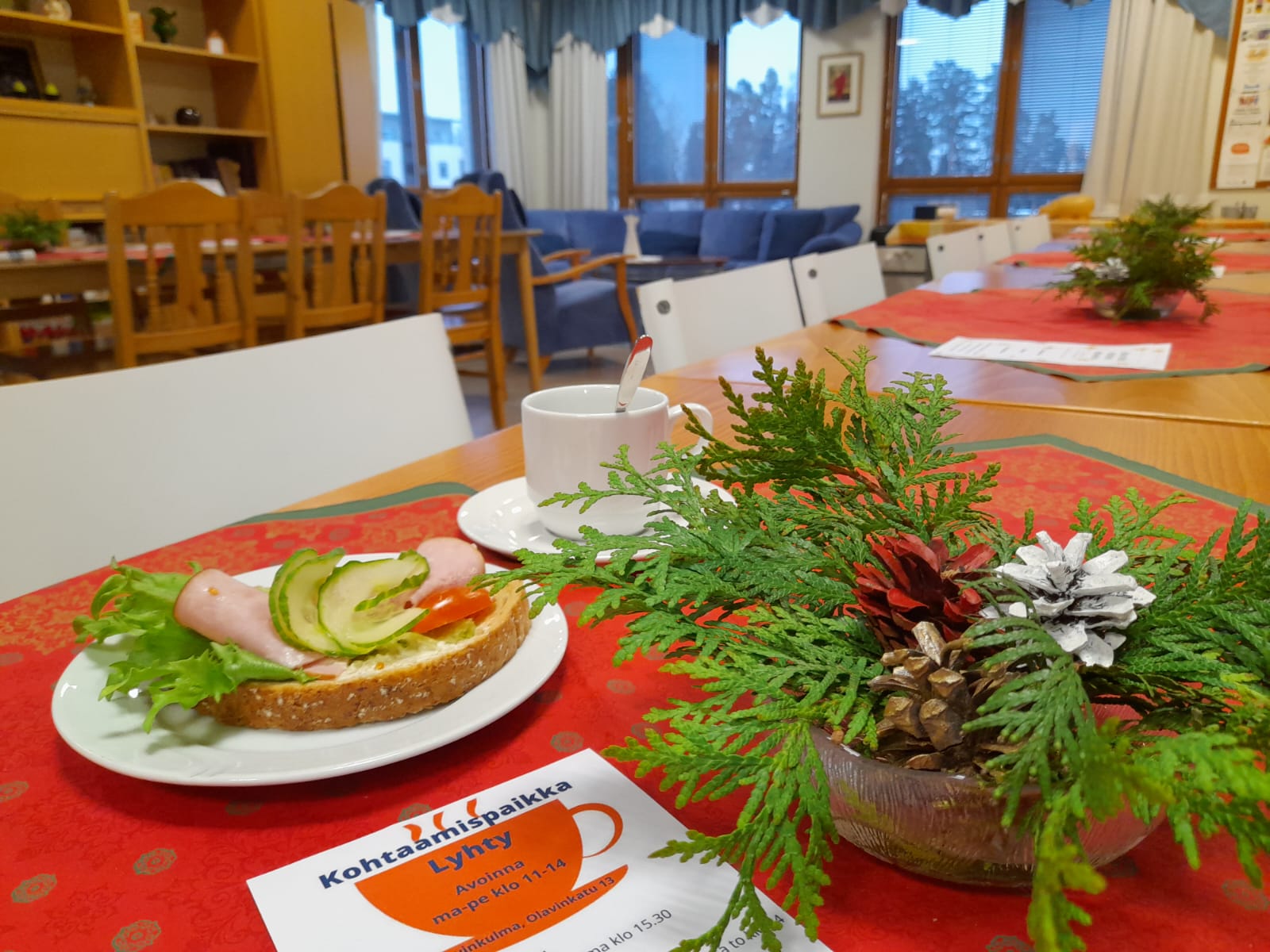 Pöytä, jolla vihreä koriste ja kahvileipä lautasella